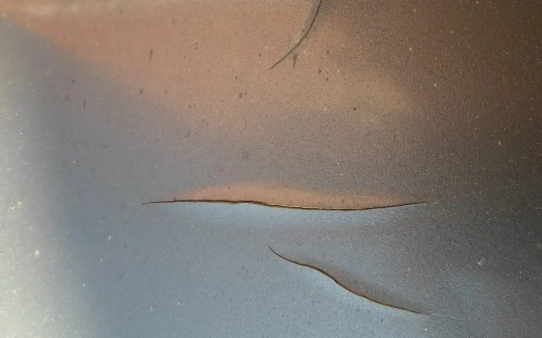 Car being carefully washed with lukewarm water, showcasing safe practices to protect paint from damage.