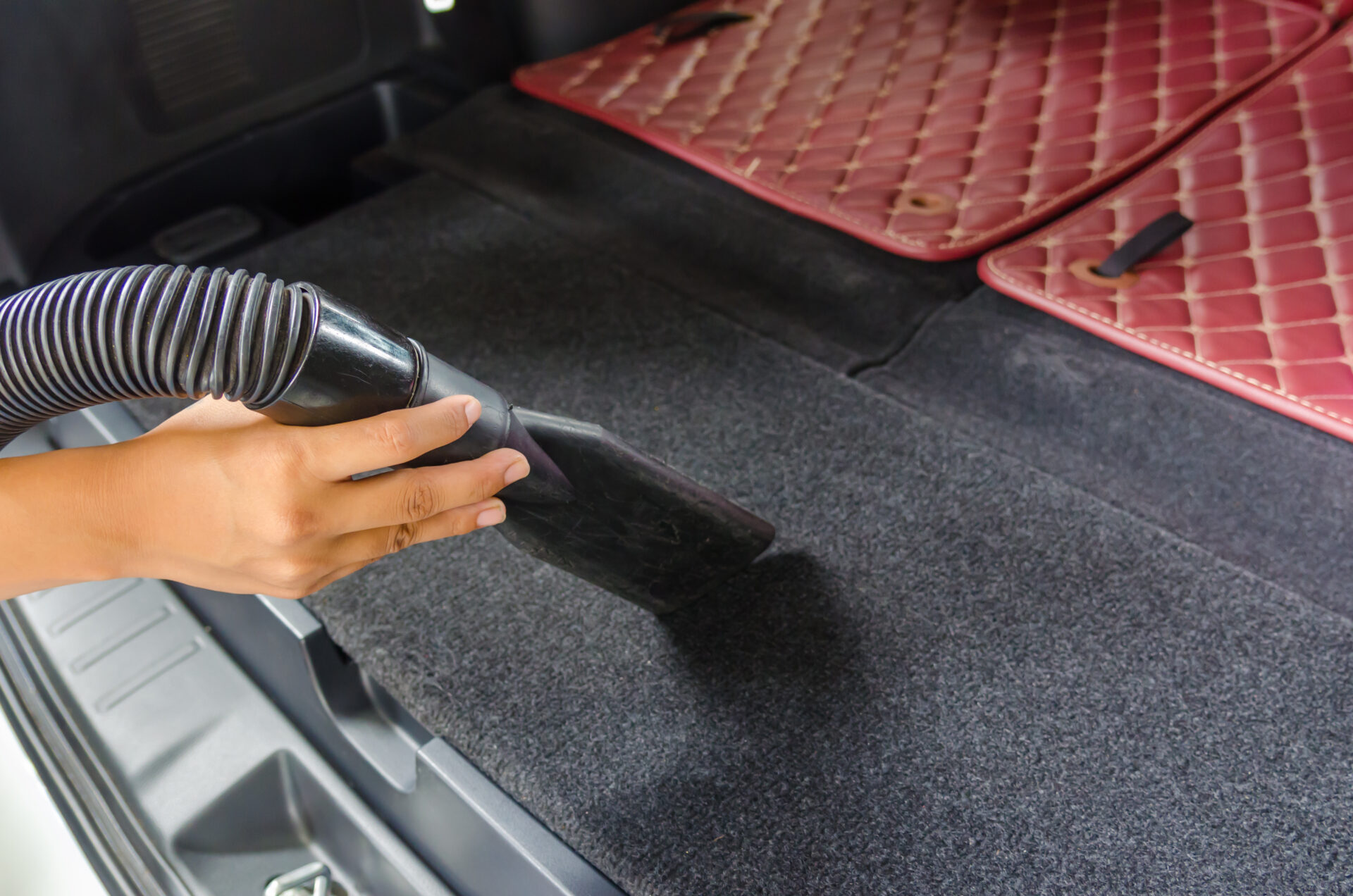 woman vacuuming car.