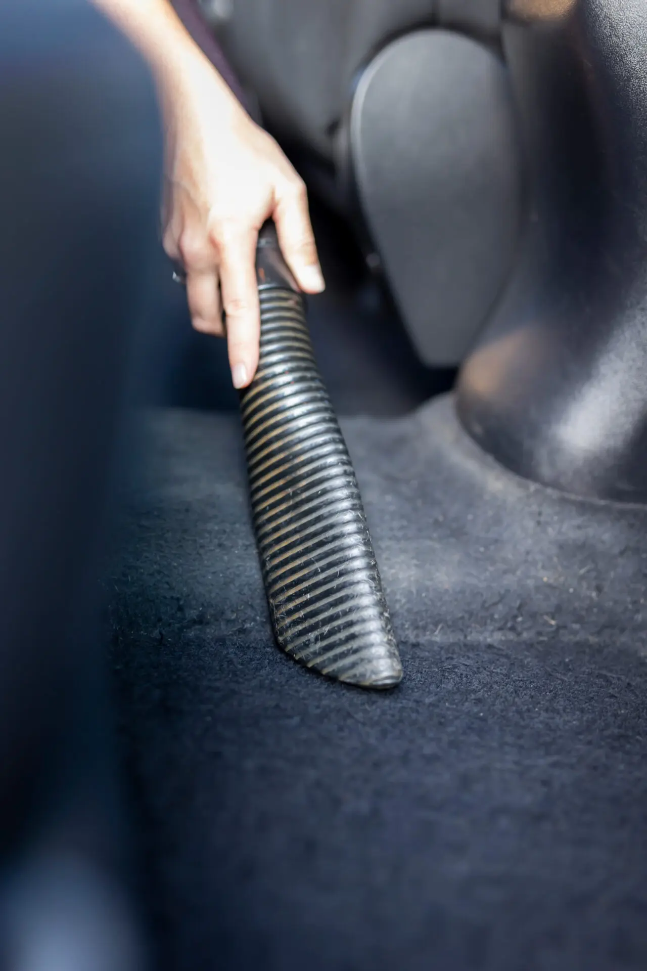 woman vacuuming car interior