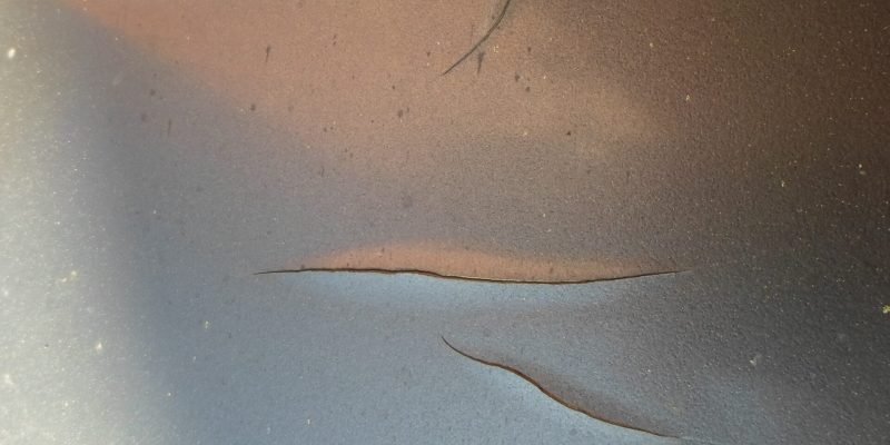 Car being carefully washed with lukewarm water, showcasing safe practices to protect paint from damage.